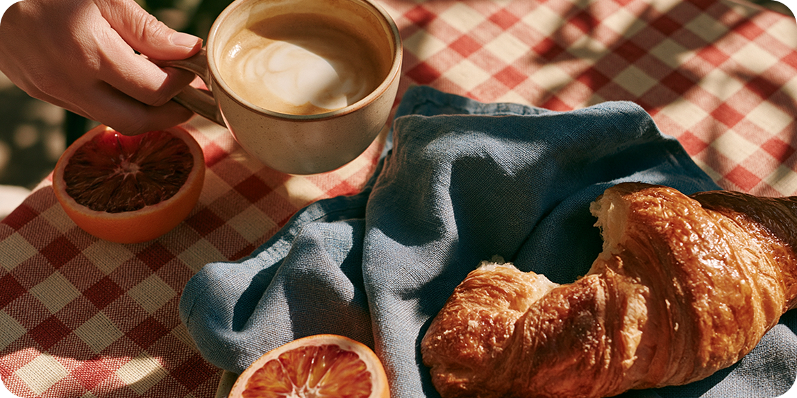 Coffee and croissant in warm sunlight